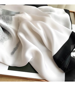 Close-up of elegant silk-like scarf texture with minimalist black and white borders