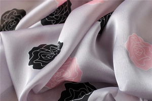 Close-up of rose flower printed silk fabric showing premium twill texture and soft luster