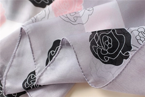Close-up of lightweight chiffon scarf showing rose floral print and fine rolled edges