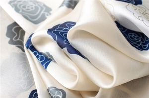 Close-up of elegant rose pattern on silk scarf with smooth satin texture and blue floral print