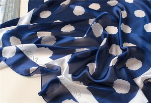 Detailed close-up of navy and white silk scarf with elegant rose floral patterns