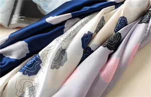 Detailed macro view showing the silky texture and rose floral pattern of the satin scarf