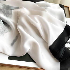Elegant silk-like long scarf with black borders and ink print on a magazine background