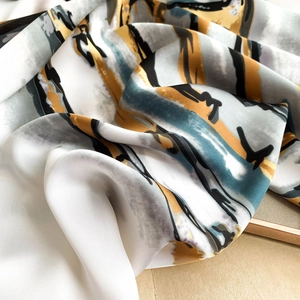Elegant abstract print satin scarf in navy and mustard yellow with smooth silk texture