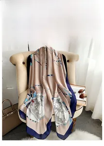 Close-up of nautical chain print silk scarf draped elegantly on a cream beige sofa