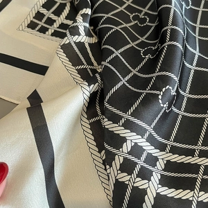 Detail of silk scarf with classic black and white rope grid pattern and smooth texture