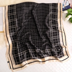 Detail of 100% silk scarf featuring elegant plaid and interlocking heart patterns
