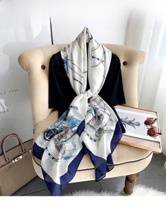 Detail of luxury chain and anchor print silk scarf draped on a mannequin
