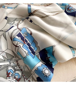 Detail of nautical chain print on white silk scarf featuring anchors and ropes