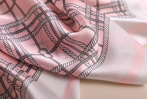 Detail of silk satin scarf showing soft texture and elegant geometric rope pattern