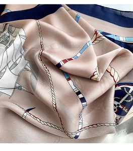Close-up of nautical print silk scarf with anchors and ropes on champagne fabric