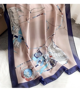 Detailed view of champagne silk scarf with nautical ship and rope print on soft plush rug