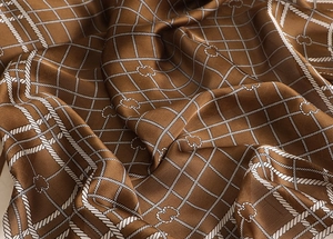 Detailed macro view of caramel brown satin scarf with white rope grid pattern and texture