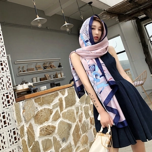 Detail of pink and blue silk scarf featuring nautical prints and chain patterns on a model