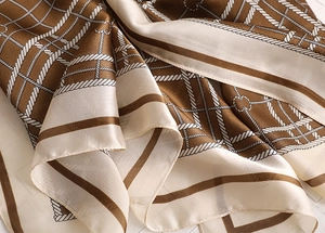 Close-up of geometric rope pattern on silky brown and beige elegant plaid scarf