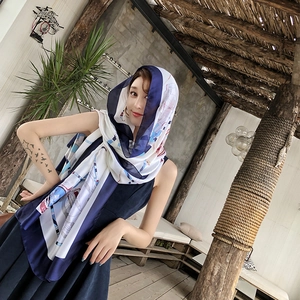 Detail of silk-feel scarf with navy blue and red geometric prints on a modern model