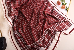 Close-up of elegant burgundy plaid silk scarf with detailed pattern and glossy texture