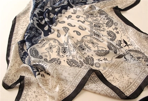 Détail d'un foulard en soie élégant avec motifs paisley et géométriques bleu et blanc