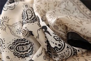 Gros plan d'un foulard en soie avec motifs Paisley noirs et blancs et texture lisse