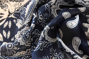 Vue macro du tissu mousseline à imprimé paisley bleu marine et blanc avec drapé élégant
