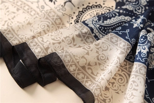 Gros plan détaillé du motif paisley sur l'écharpe en soie bleu marine et beige élégante