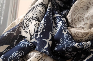 Détail d'une écharpe en soie aux motifs cachemire avec texture fluide et imprimés bleus