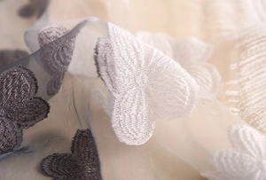 Dettaglio del ricamo a farfalla bianca elegante su un delicato tessuto di pizzo