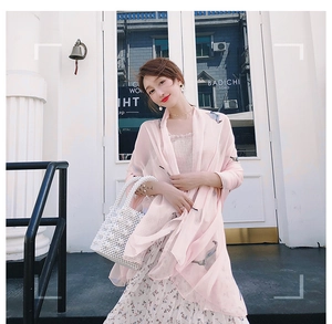 Detail of elegant light pink printed chiffon shawl paired with a pearl handbag