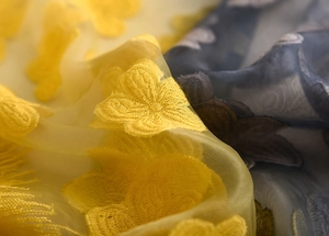 Dettaglio del ricamo a farfalla su tessuto di organza semitrasparente della sciarpa