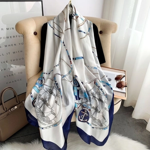 Elegant nautical chain print silk scarf in beige and navy blue on a hanger