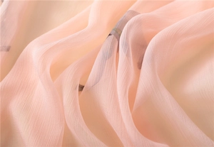 Macro detail of soft light pink pleated silk scarf with fine vertical fabric texture
