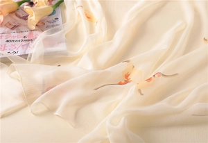 Detail of elegant calla lily floral scarf with soft crinkle texture on a beige fabric