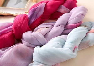 Close-up of soft pink, purple, and blue chiffon scarves showing light fabric texture