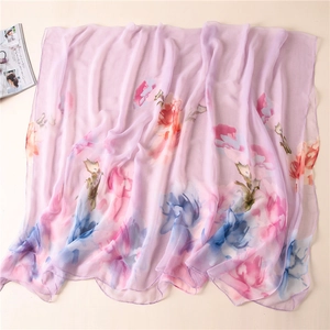 Detailed view of light purple chiffon scarf with large colorful floral print on flat lay