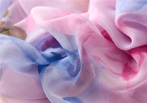 Close-up of floral chiffon fabric showing sheer texture and pink purple floral pattern