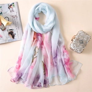 Detail of light blue floral chiffon shawl with elegant prints and soft texture