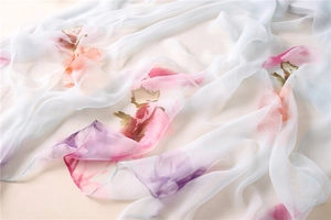 Macro detail of high-quality chiffon scarf featuring pastel floral prints and airy texture