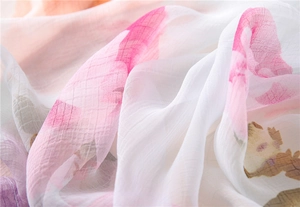 Macro detail of breathable chiffon fabric with pink floral print for beach shawls