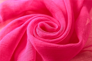 Detail of rose pink chiffon shawl fabric showing elegant vertical pleated texture and soft feel