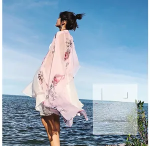 Pink chiffon floral wrap scarf on model at the beach for sun protection outdoors