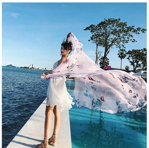 Lightweight pink floral scarf fluttering by the pool with rose prints and sheer texture
