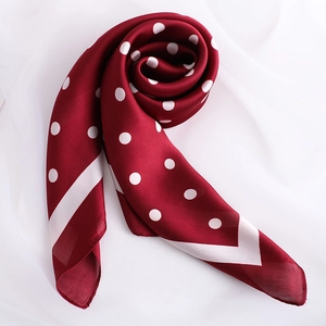 Détail d'un foulard en satin bordeaux à pois avec texture soyeuse et bordures blanches