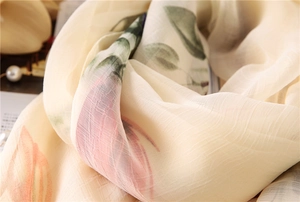 Macro detail of breathable beige silk scarf with floral prints and striped texture