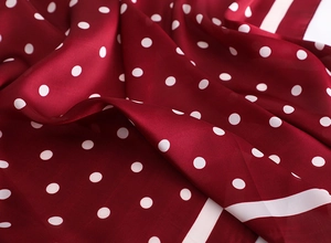 Vue détaillée du satin doux et des pois blancs classiques sur le foulard rouge vin