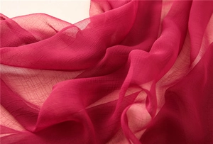 Nahaufnahme von magentafarbenem Chiffonstoff mit feiner Textur und transparentem Finish
