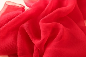 Makroansicht der roten Seiden-Chiffon-Stola mit eleganter Plissee-Textur und weichem Faltenwurf