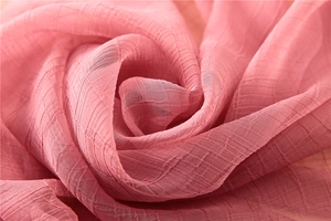 Detaillierte Makroansicht der weichen rosa Faltenstruktur für ein elegantes Seidenschal