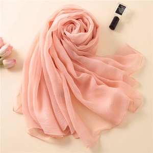 Detailansicht eines rosa plissierten Seidenschals mit eleganter und atmungsaktiver Textur