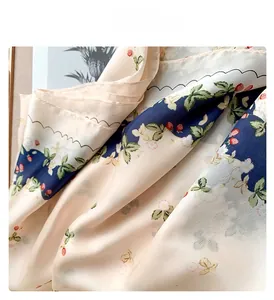 Detailed view of overlock stitching on floral silk scarf with strawberry print