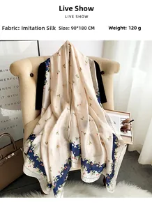Detail of silk-like floral scarf 90x180cm draped on chair with summer accessories